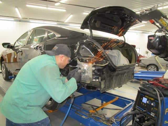 a technician working on a car at Bates Collision