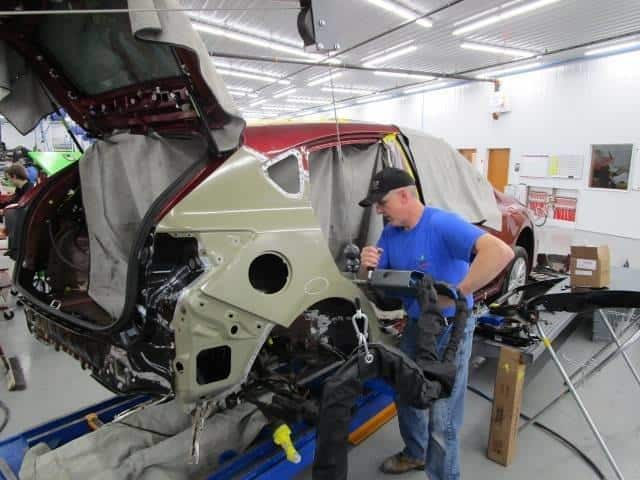 a technician at Bates Collision repairing the back of a car
