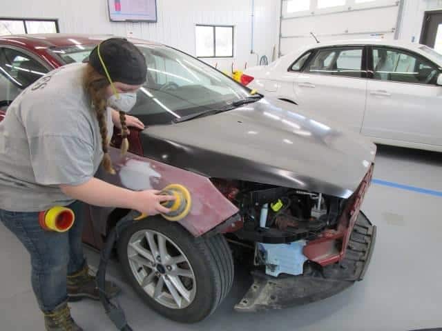 a Bates Collision technician buffing out the front of a car