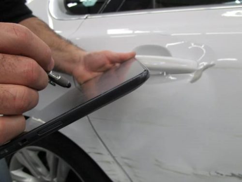 an employee entering information into a tablet at Bates Collision